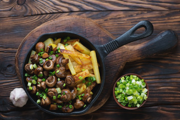 Roasted champignons with potato in a rustic wooden setting