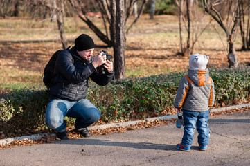 Father photographing son in the Park