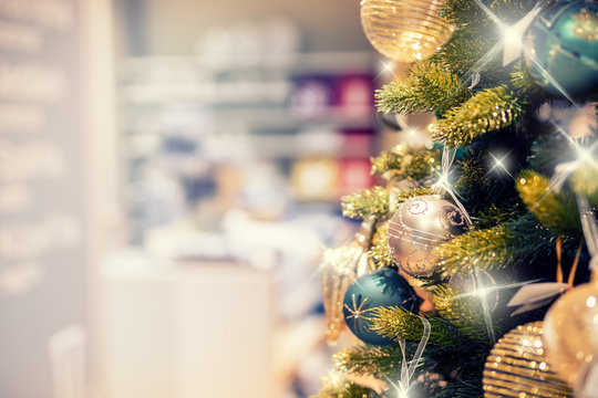 Christmas tree with gold decoration in shopping mall.Christmas clearance sales at the shopping mall. Elegant Christmas tree in a shopping mall.