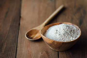 Oat flour in old wooden bowl