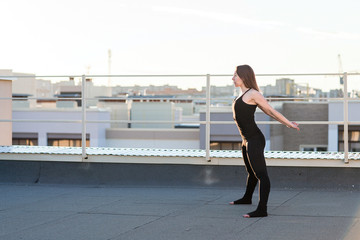 Young woman doing yoga on the roof