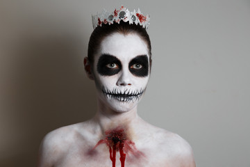 portrait of girl with make-up for halloween. gray background, isolated. unusual body art