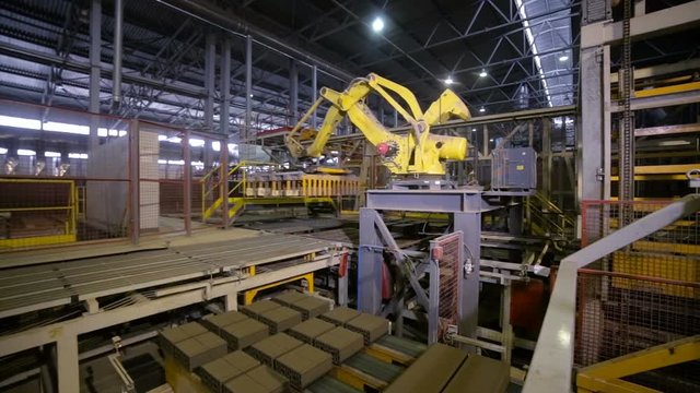 Industrial robot. Robotic arm assembling products on a modern plant. HD.