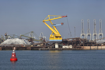 Port cargo crane and sand over blue sky background