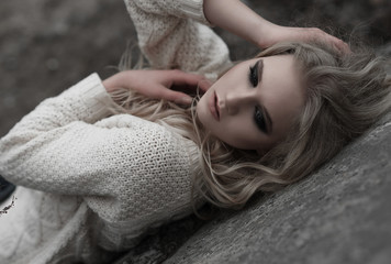 Close up of beautiful young  blonde woman with blue eyes in white pullover. .Winter, spring, outdoor portrait. 