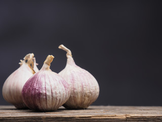 Three fresh organic garlic on wood