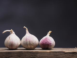Three fresh organic garlic on wood