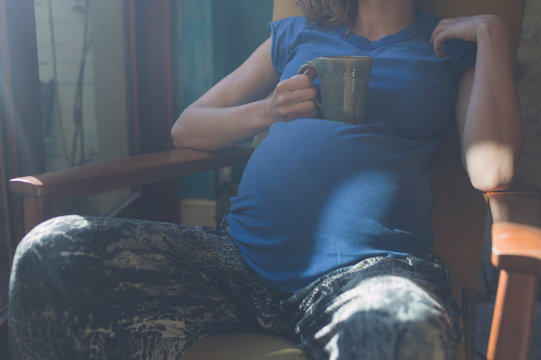 Pregnant woman drinking tea by