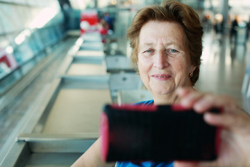 Portrait of beautiful 70 years old woman sitting in the airport