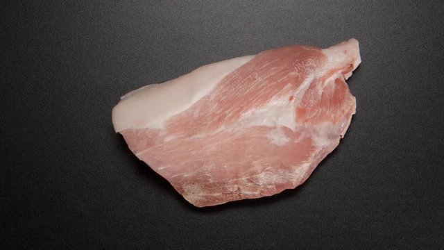 TIME-LAPSE: Unfreezing a pork steak on black table