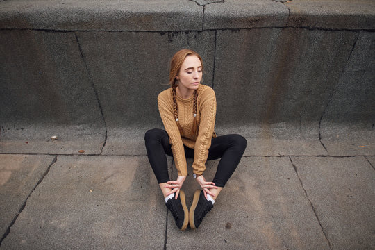 Blonde girl sutting on the ground