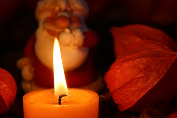 Kerze brennt mit Weihnachtsmann Figur