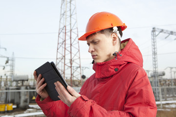 Engineer at electrical substation using a tablet computer