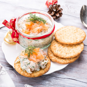 Smoked Salmon, Soft Cheese And Dill Spread, Mousse, Pate, Rillette In A Jar With Crackers On White Wooden Background. Delicious Christmas Themed Dinner Table. Holiday Concept.