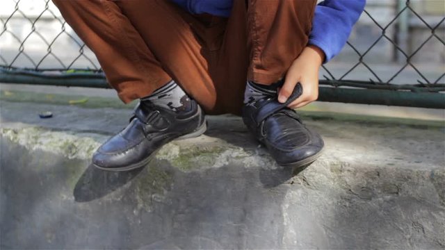 boy sitting near school/child sitting on the fence and school truant school