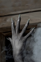 Black hands of the devil on wall background