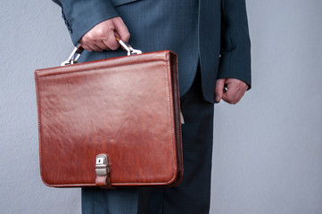 Brown briefcase in hand, a businessman in the office  