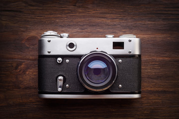 Old retro camera on vintage wooden boards abstract background