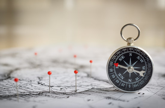 Magnetic compass on a world map conceptual of global travel , tourism and exploration. Macro photo.