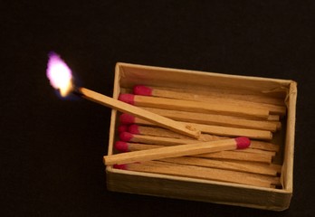 scatola fiammiferi con fiammifero acceso