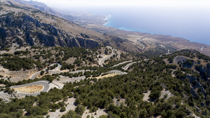 serpentine road at montains near blue sea