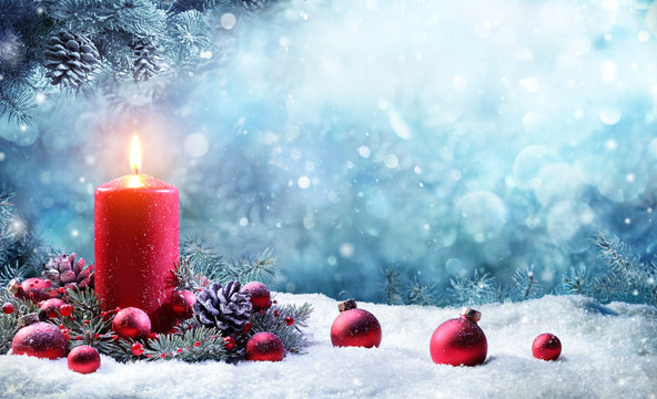 Advent Candle With Fir Branches Burning In Snowy Scene
