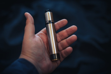Vaping device in in the man's hand. Electronic cigarette, vape