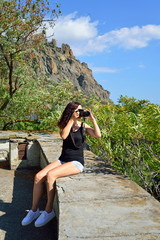 Girl tourists taking pictures on the background of the Karadag