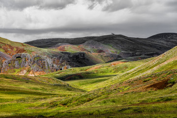 Fototapeta na wymiar Icelandic landscape with hillsides and cloudy sky 