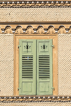 Detail of an old swiss chalet with shingles and green painted withered wooden window shutters