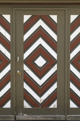 Fototapeta premium A wooden garage door with diamond pattern painted in brown, white and red color