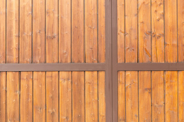 closeup of a wooden garage door with vertical boards and metal grid