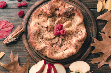 pie with cinnamon and raspberry on a wooden table