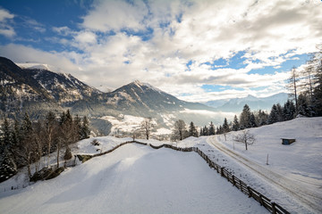 Winterlandschaft mit vereister Strasse in den Alpen bei Salzburg in Österreich