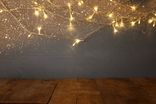 empty table in front of Christmas warm gold garland lights