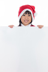 Happy Asian Chinese little santa girl holding blank board