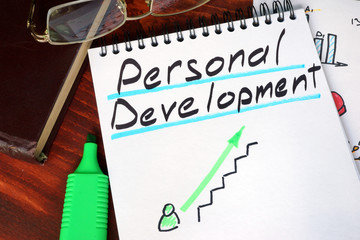 Notepad with personal development on a wooden surface.