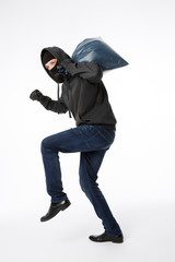 Thief slinking with blue bag