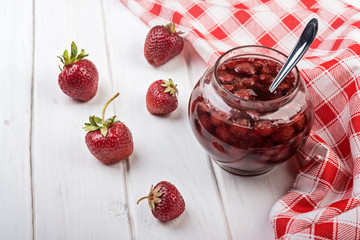 Strawberry jam  in a jar on wooden table