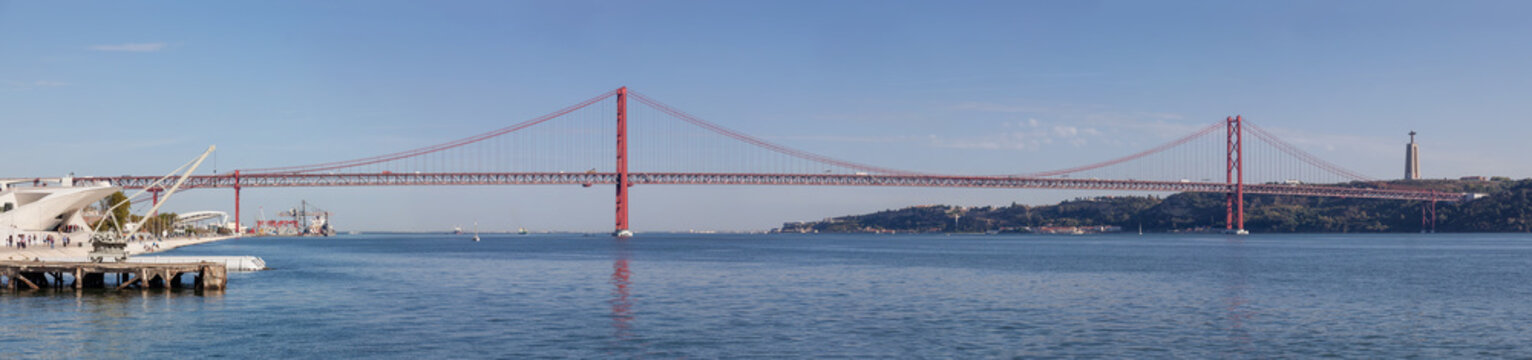 Lisbon, Portugal. The 25 de Abril bridge spanning over the Tagus River. On the right it’s seen the famous the Cristo-Rei Sanctuary.
