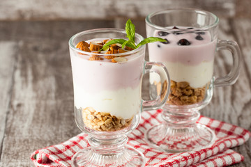 Fresh yogurt with granola and muesli, fresh berries and almonds nuts. Healthy morning breakfast of smoothie.