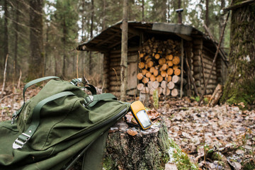 Man the hunter with a GPS navigator in the forest. A man found a hunting lodge with the navigator....
