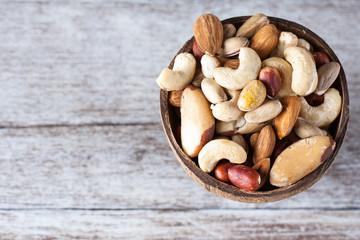 Naklejka na ściany i meble Healthy mix nuts on wooden background. Almonds, hazelnuts, cashews, peanuts, brazilian nuts