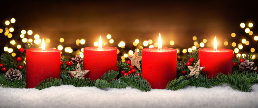 Advent Dekoration mit vier Kerzenflammen, Lichtern, Schnee, Tannenzweigen und Holz Hintergrund