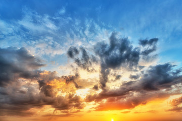 Naklejka na ściany i meble Cumulus sunset clouds with sun setting down
