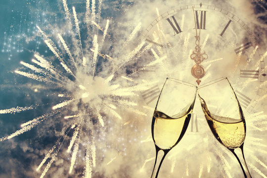 Glasses with champagne and clock close to midnight
