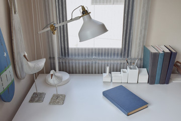work table with lamp,pencils and books in working room