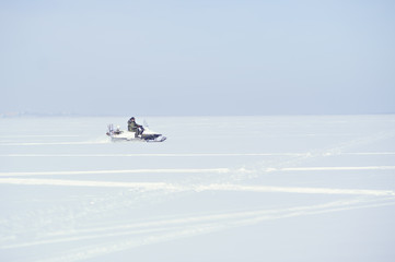 Fototapeta na wymiar A man rides a snowmobile. Winter. A lot of snow.