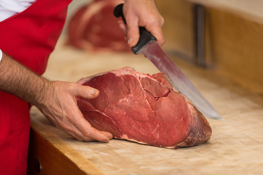 Close up of butcher cutting meat