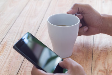 using smart phone and drink coffee at cafe